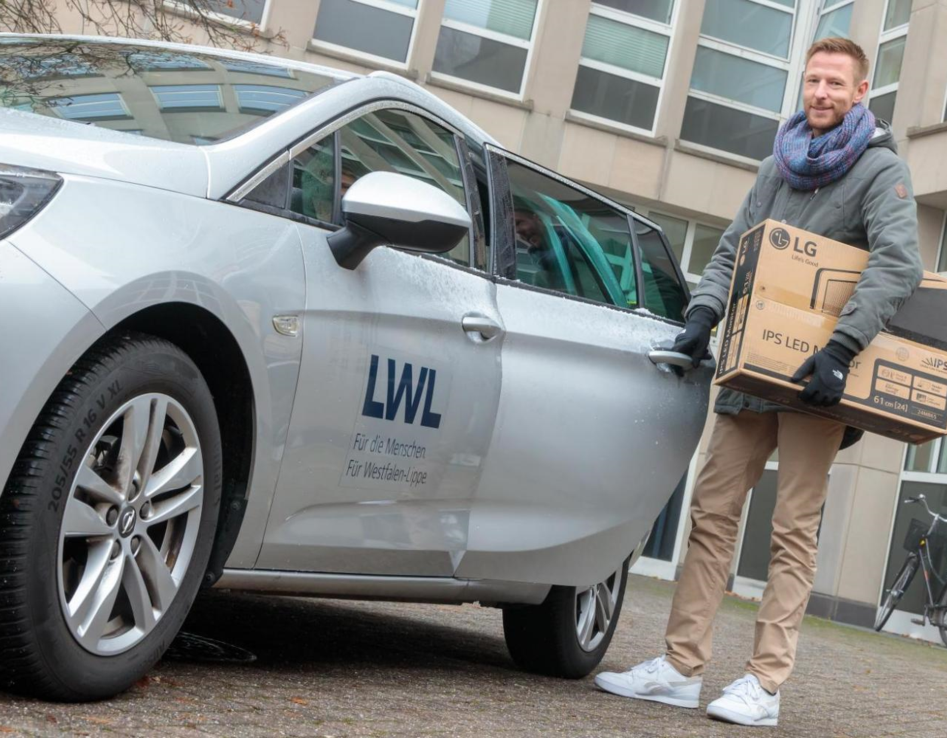 Ein Servicemitarbeiter der LWL.IT lädt Hardware in einen Dienstwagen, die vor Ort bei einem Kunden aufstellt werden soll.