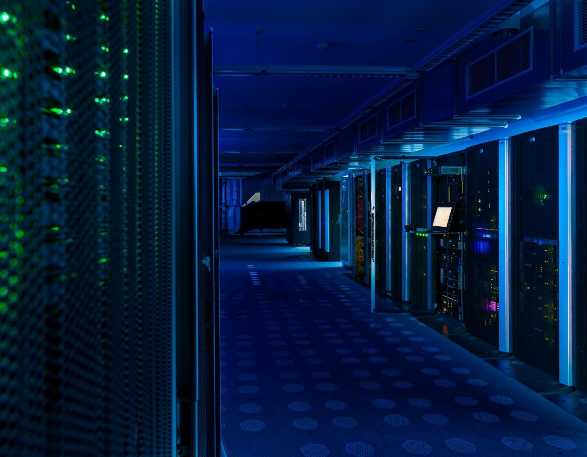 Blick in den Serverraum, wo viele Serverschränke in einer Reihe stehen