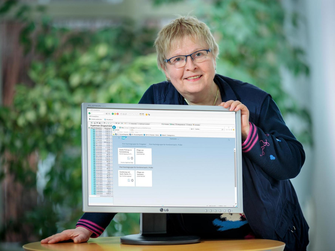 Eine Mitarbeiterin zeigt ein Bild auf einem Monitor.